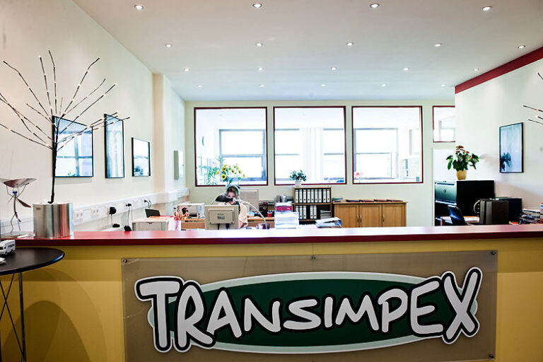 Büroraum mit Transimpex-Schriftzug an einer Theke